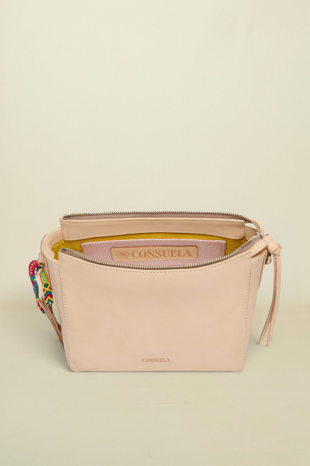 Beige handbag with colorful strap on a white background