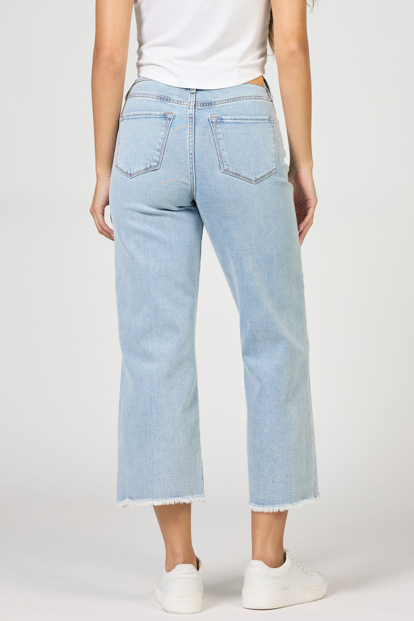 Light blue jeans worn by a person on a white background