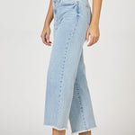 Light blue jeans worn by a person on a white background