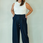 Woman wearing navy wide leg drawstring pants with white tee