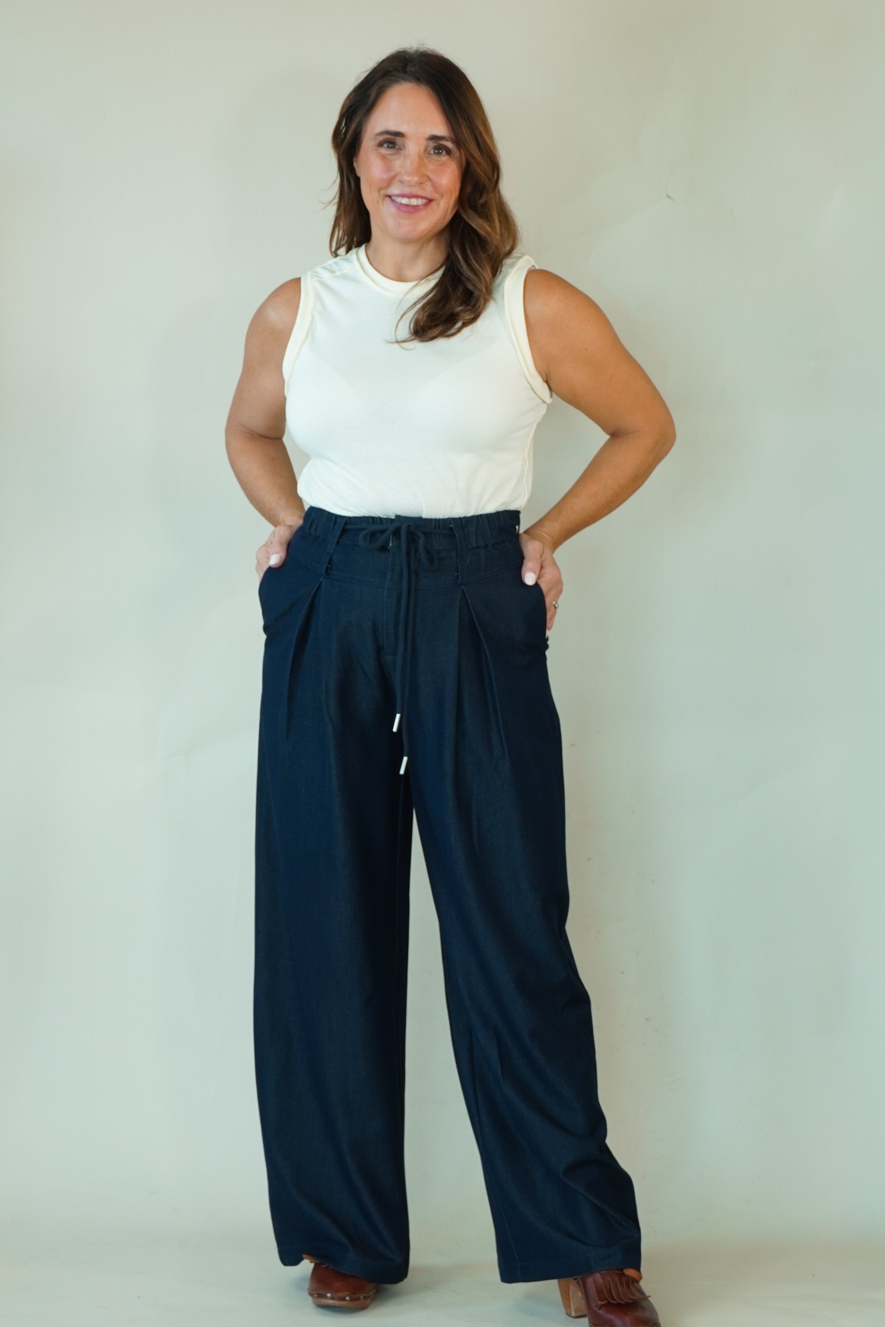 Woman wearing navy wide leg drawstring pants with white tee