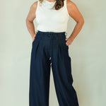 Woman wearing navy wide leg drawstring pants with white tee 
