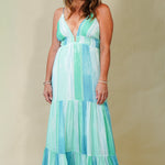 Woman wearing a colorful dress against a plain background