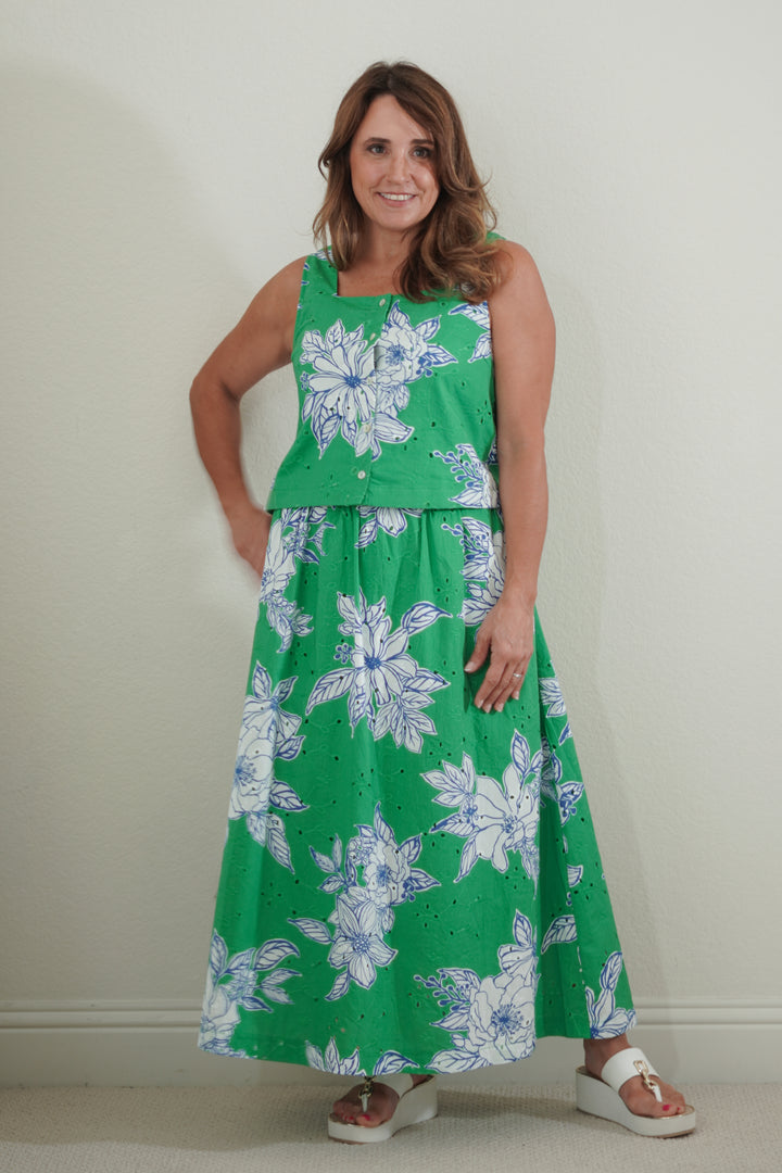 Woman wearing a green floral dress against a plain background