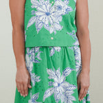 Woman wearing a green floral dress against a plain background