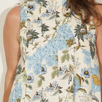 Woman wearing a floral dress standing in front of a mirror.