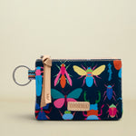 Small pouch with colorful insect design on a beige background