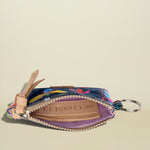 Colorful keychain pouch with floral design on a beige background