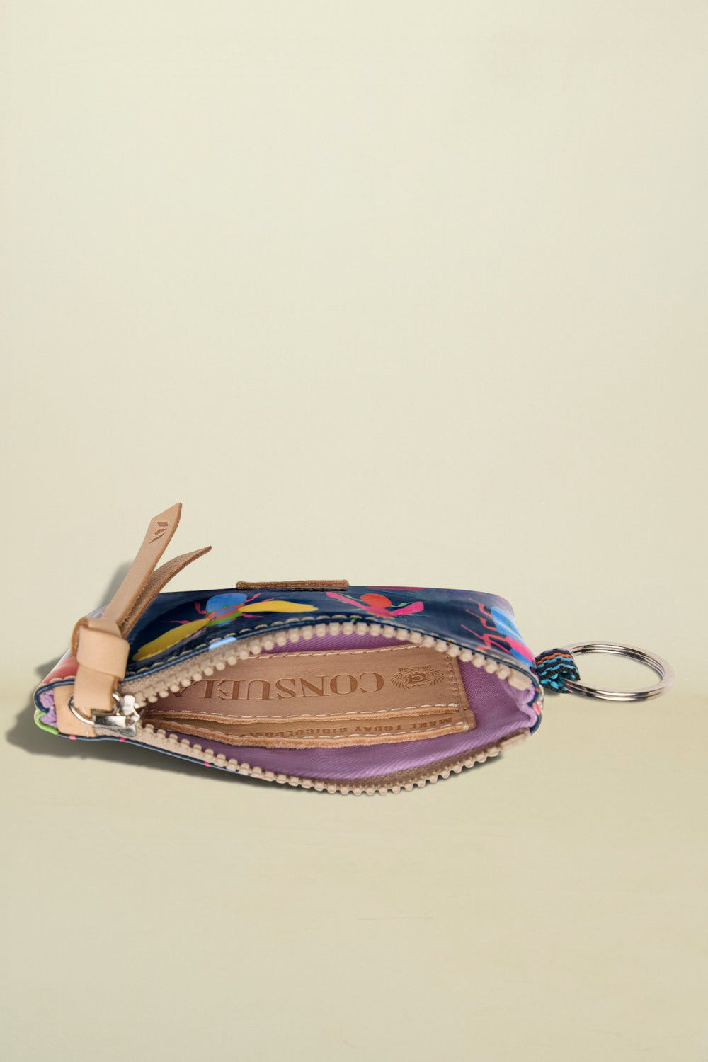 Colorful keychain pouch with floral design on a beige background