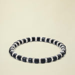 Black beaded bracelet with silver accents on a white background