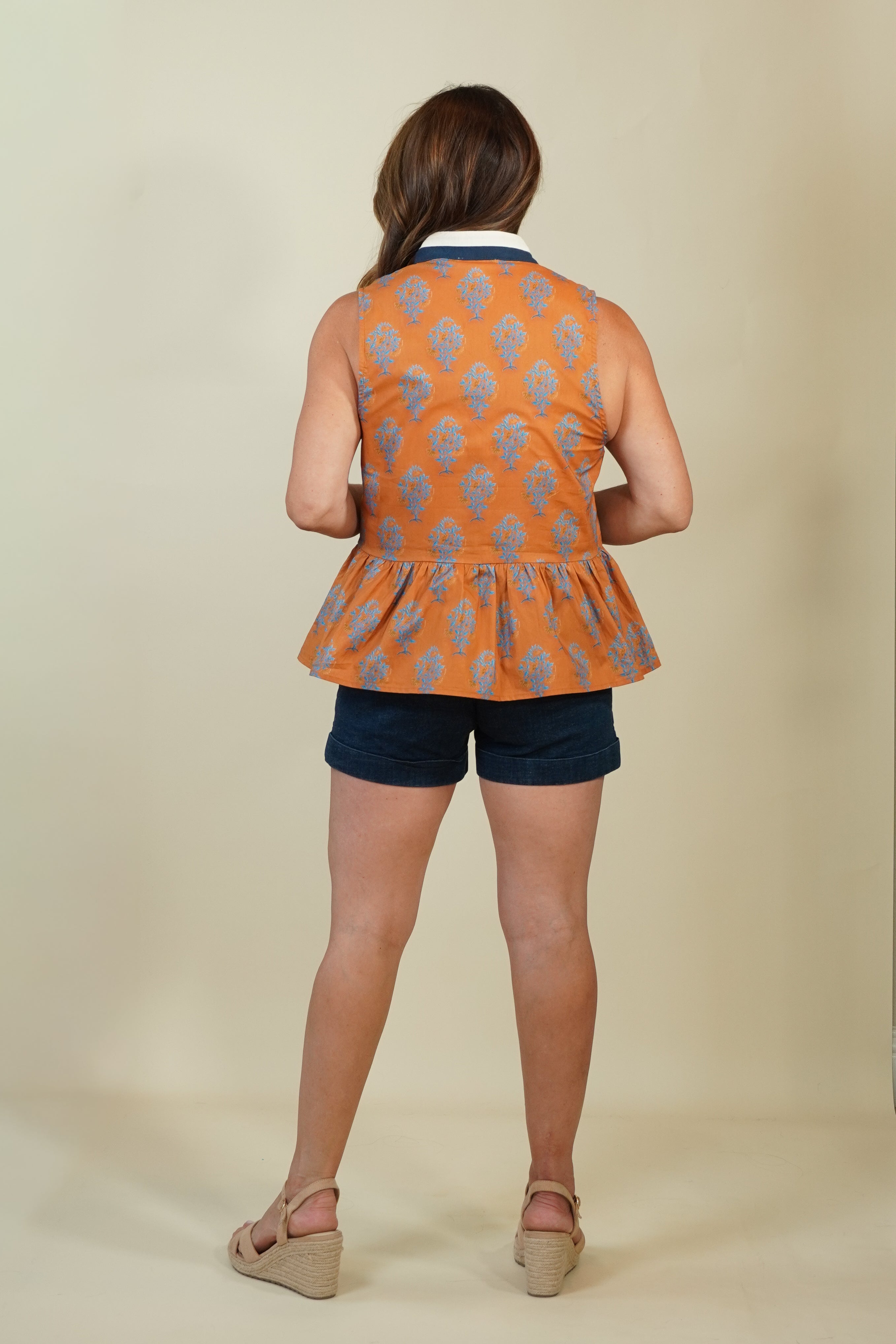 Model wearing rust block print with a navy-and-cream V-neck that gives it just enough polish, and a peplum hem that's flattering without being fussy. 