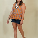 Model wearing rust block print with a navy-and-cream V-neck that gives it just enough polish, and a peplum hem that's flattering without being fussy. 