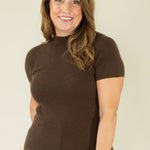 Woman wearing brown ribbed mock neck sweater with cow print pants