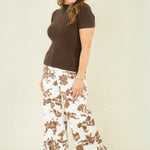 Woman wearing brown ribbed mock neck sweater with cow print pants