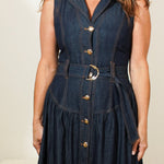 Woman wearing a long denim dress with buttons in a room.