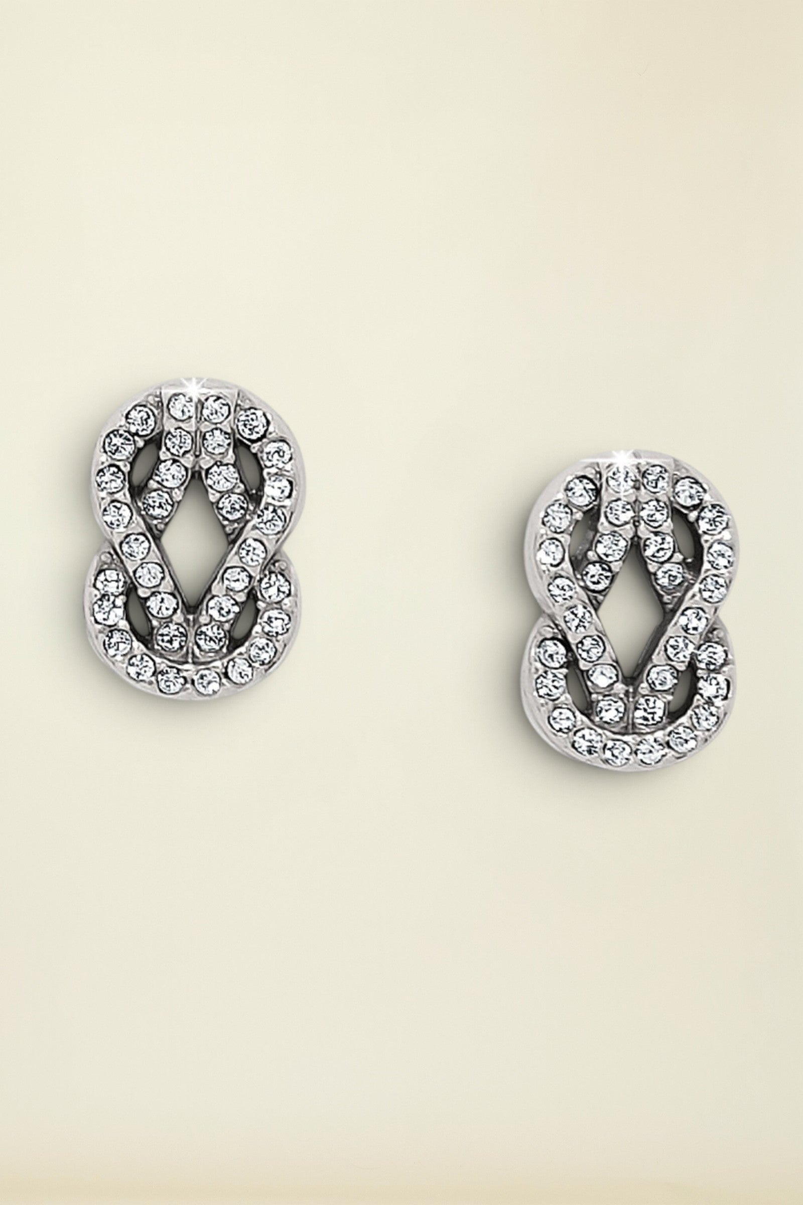 Pair of silver earrings with crystal detailing on a white background