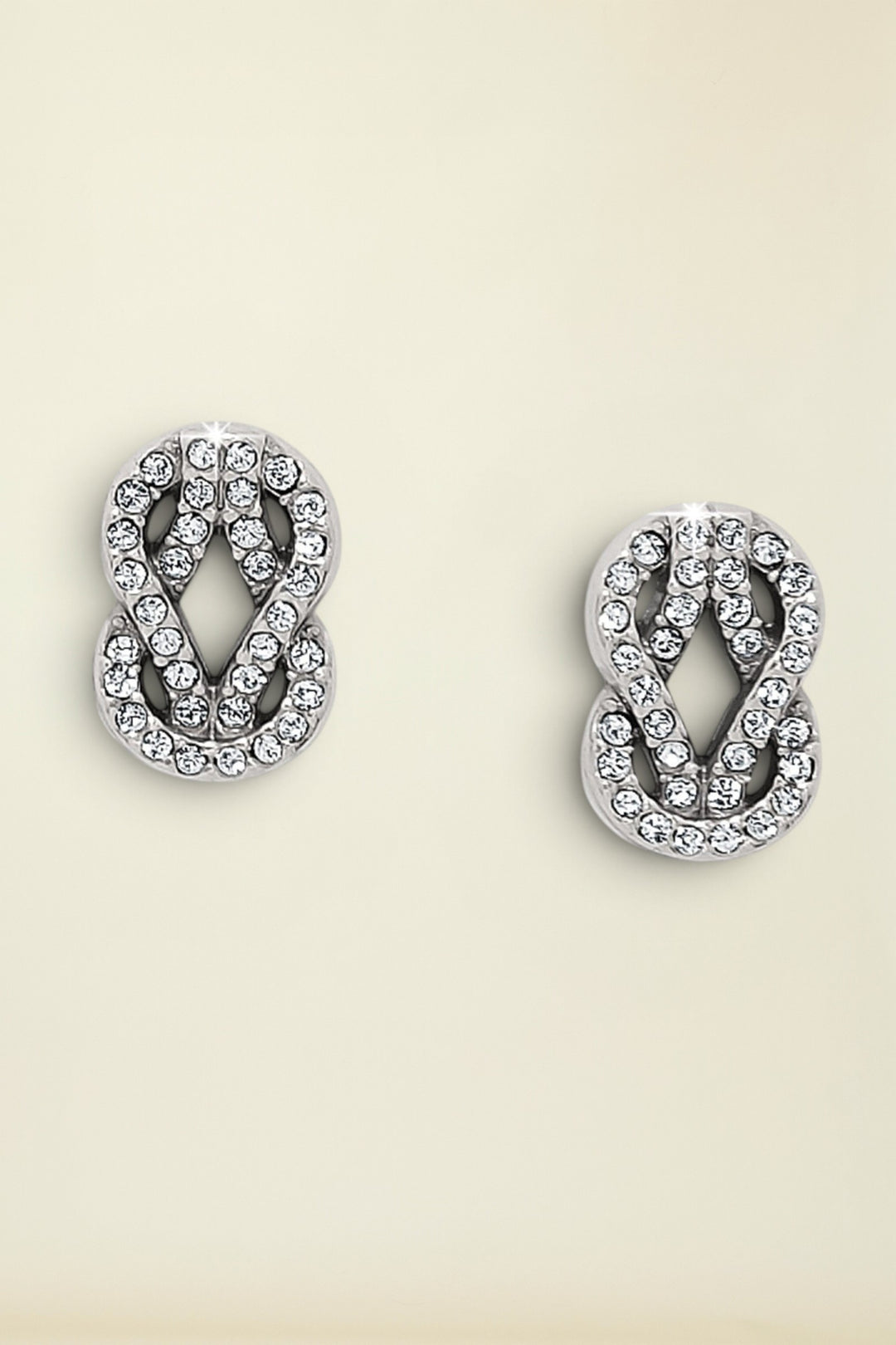 Pair of silver earrings with crystal detailing on a white background