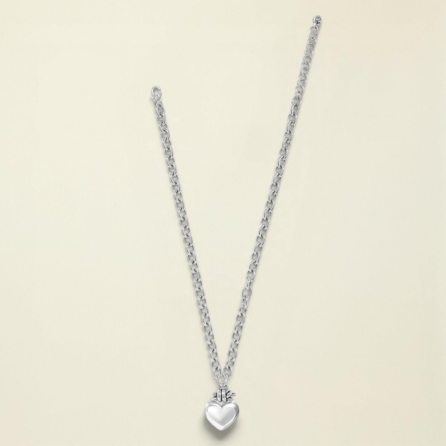 Silver necklace with a heart pendant on a white background