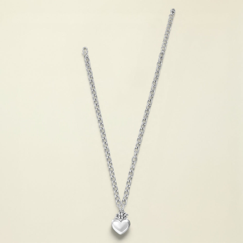 Silver necklace with a heart pendant on a white background