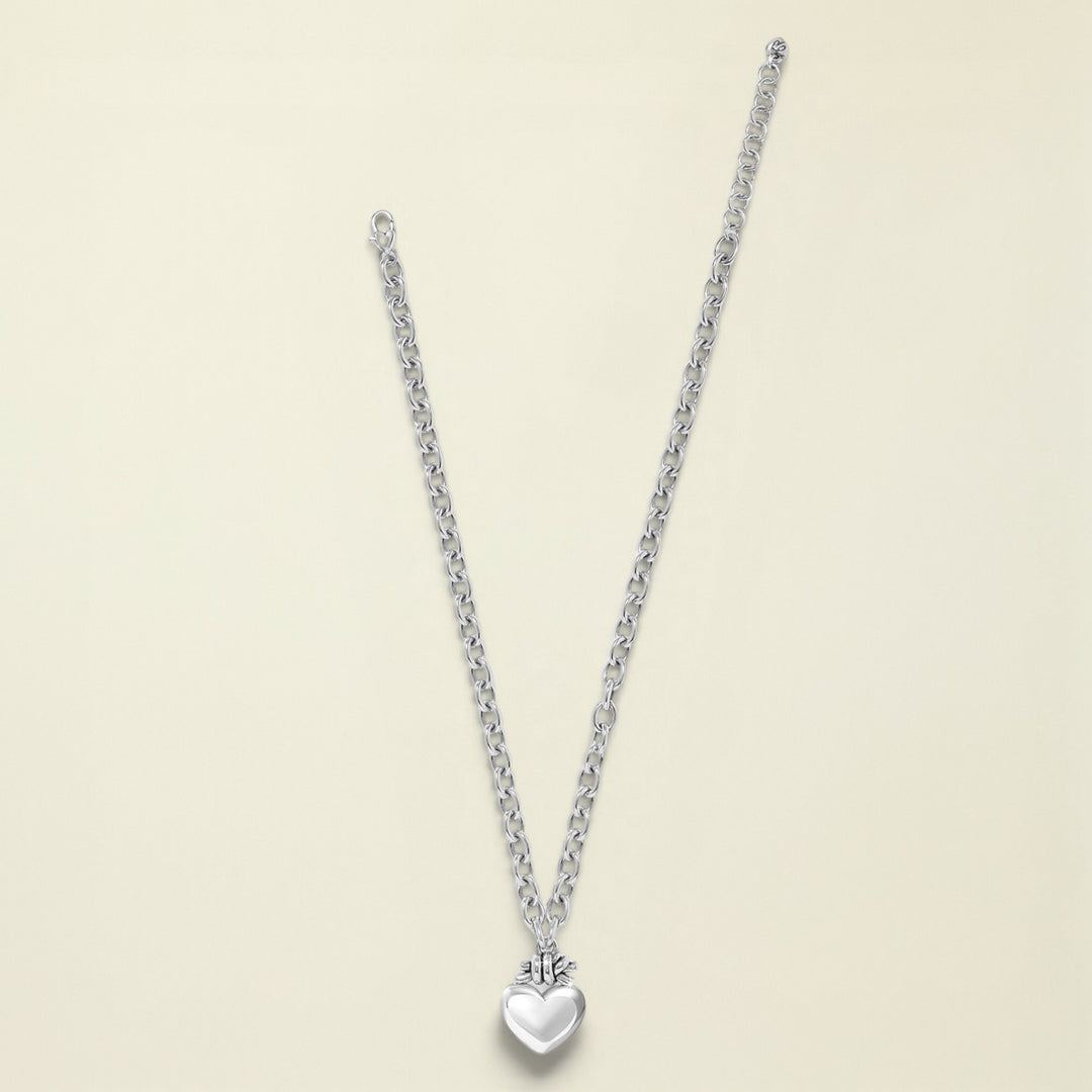Silver necklace with a heart pendant on a white background