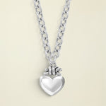Silver necklace with a heart pendant on a white background