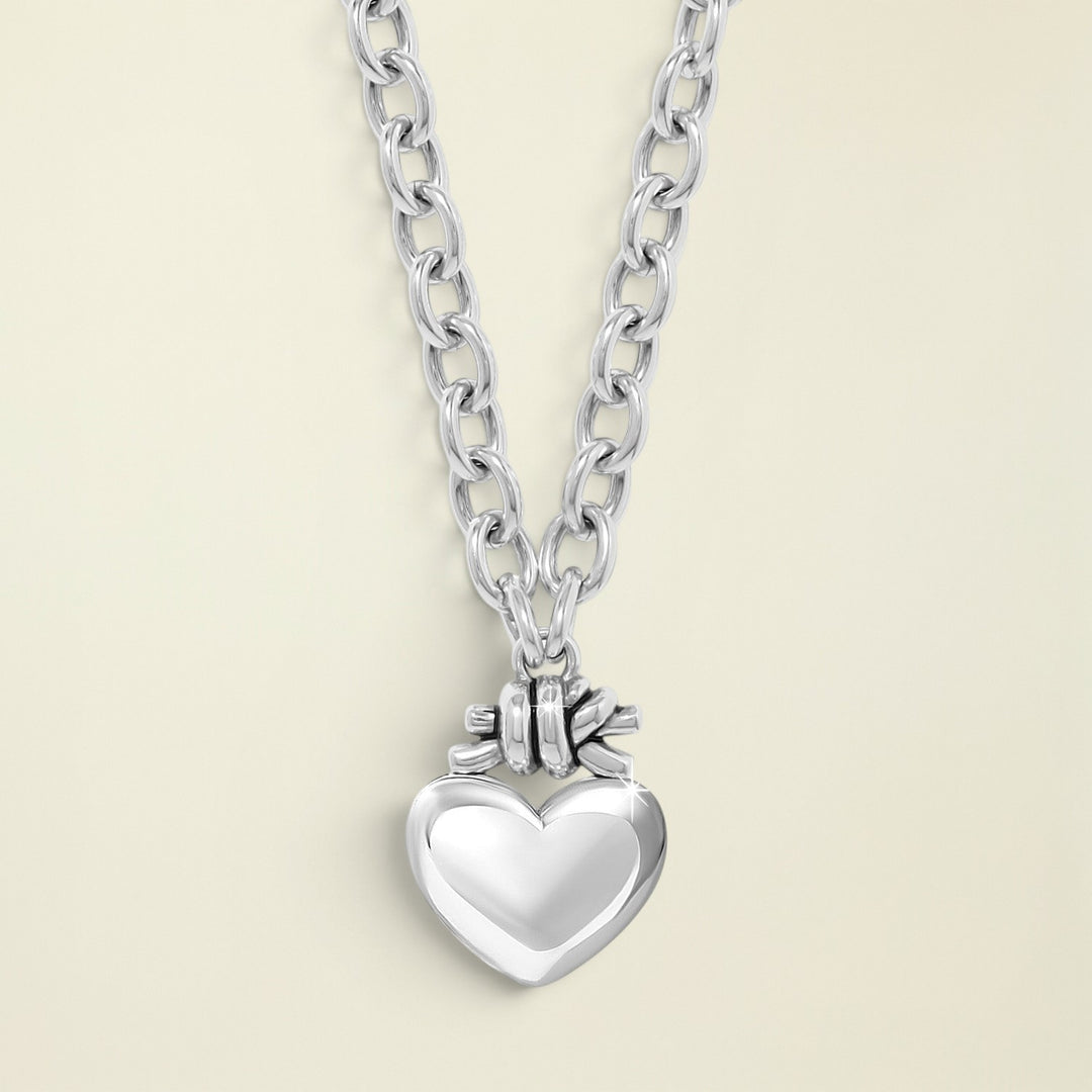 Silver necklace with a heart pendant on a white background