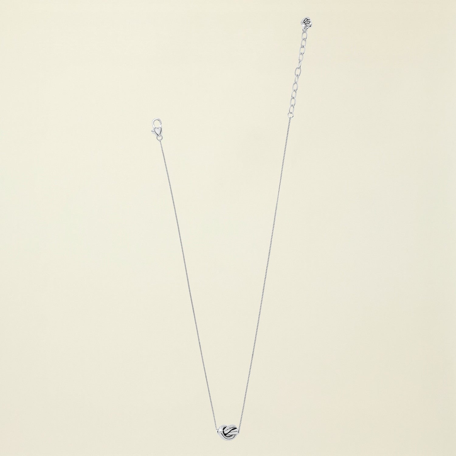 Silver necklace with a heart pendant on a white background