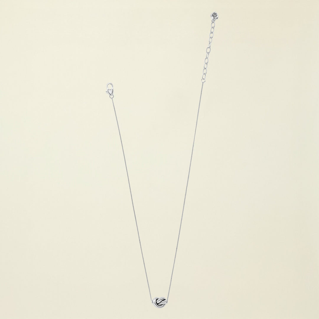 Silver necklace with a heart pendant on a white background