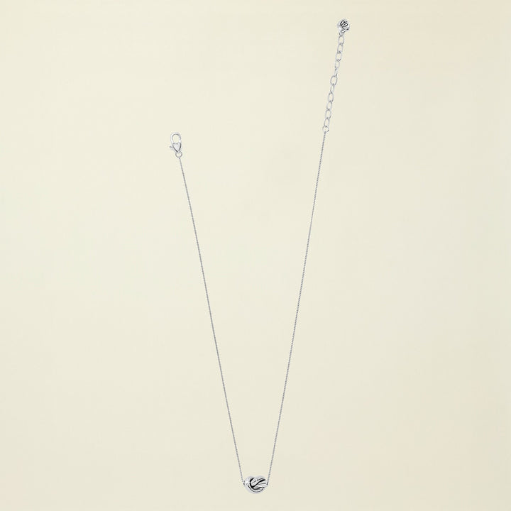Silver necklace with a heart pendant on a white background