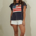 Woman wearing a t-shirt with an American flag design against a plain background
