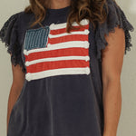 Woman wearing a t-shirt with an American flag design against a plain background