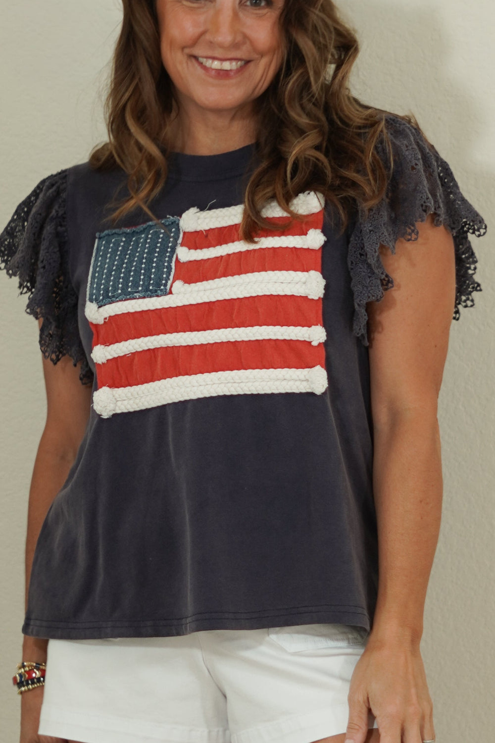 Woman wearing a t-shirt with an American flag design against a plain background