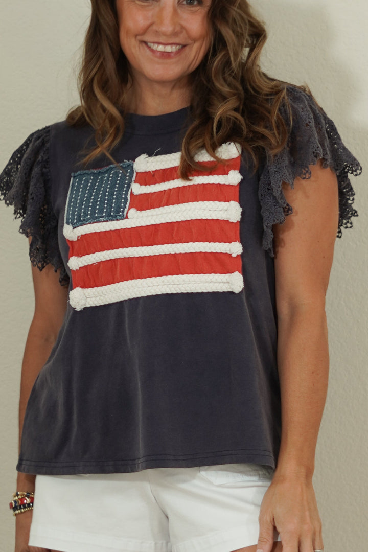 Woman wearing a t-shirt with an American flag design against a plain background