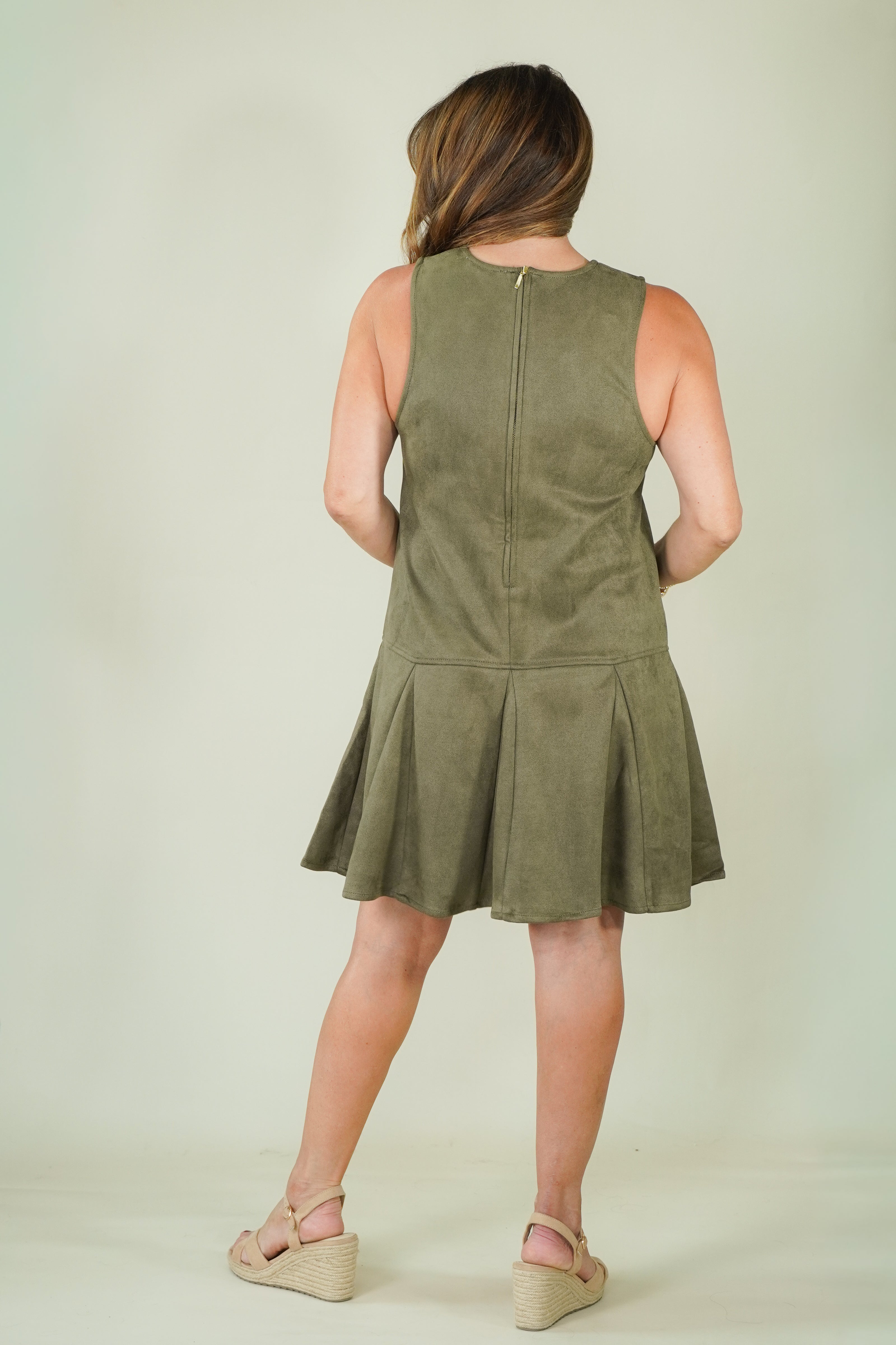 Woman wearing olive suede racing stripe dress with tan wedges back view of dress