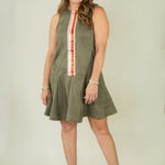 Woman wearing olive suede racing stripe dress with tan wedges