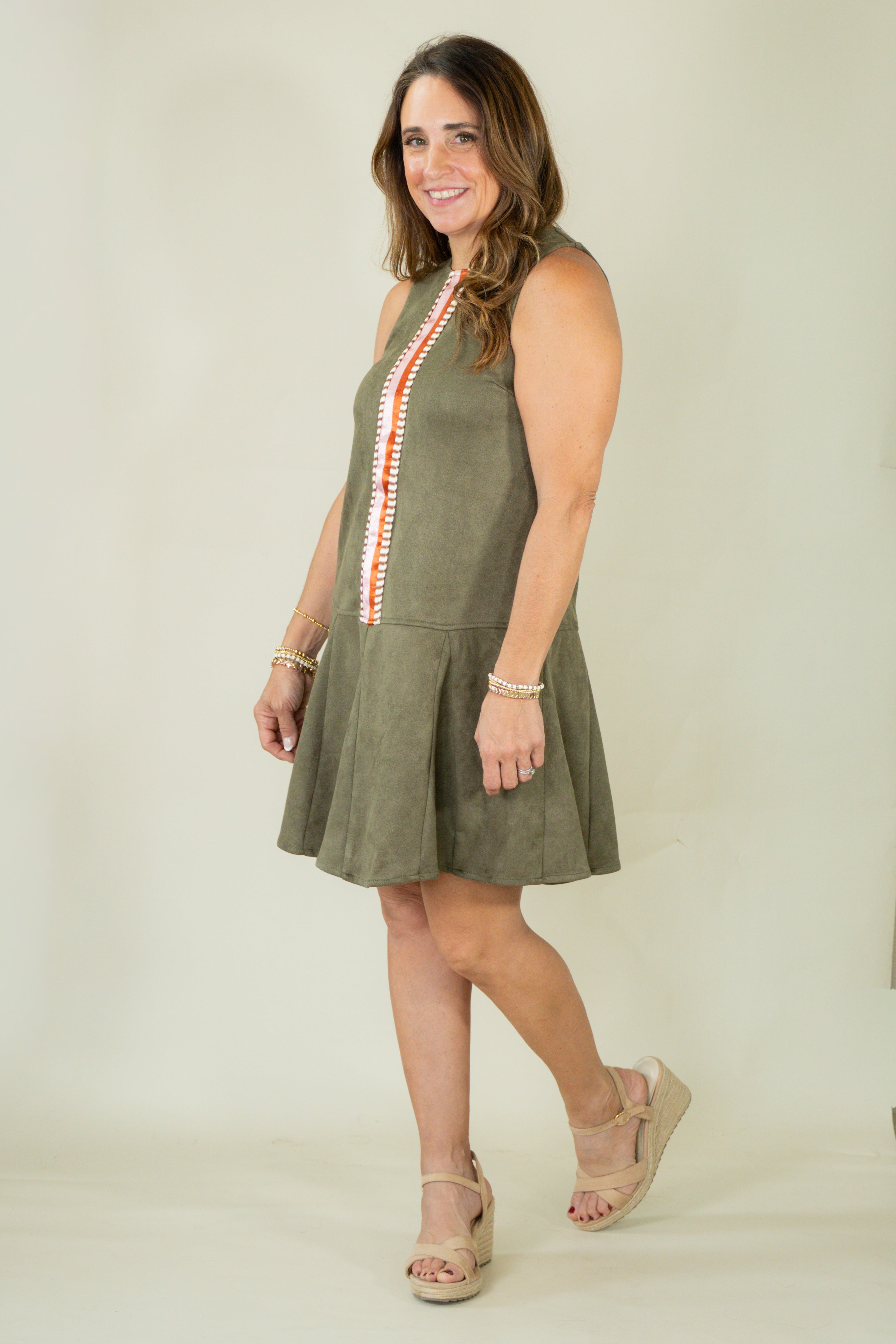 Woman wearing olive suede racing stripe dress with tan wedges
