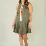Woman wearing olive suede racing stripe dress with tan wedges