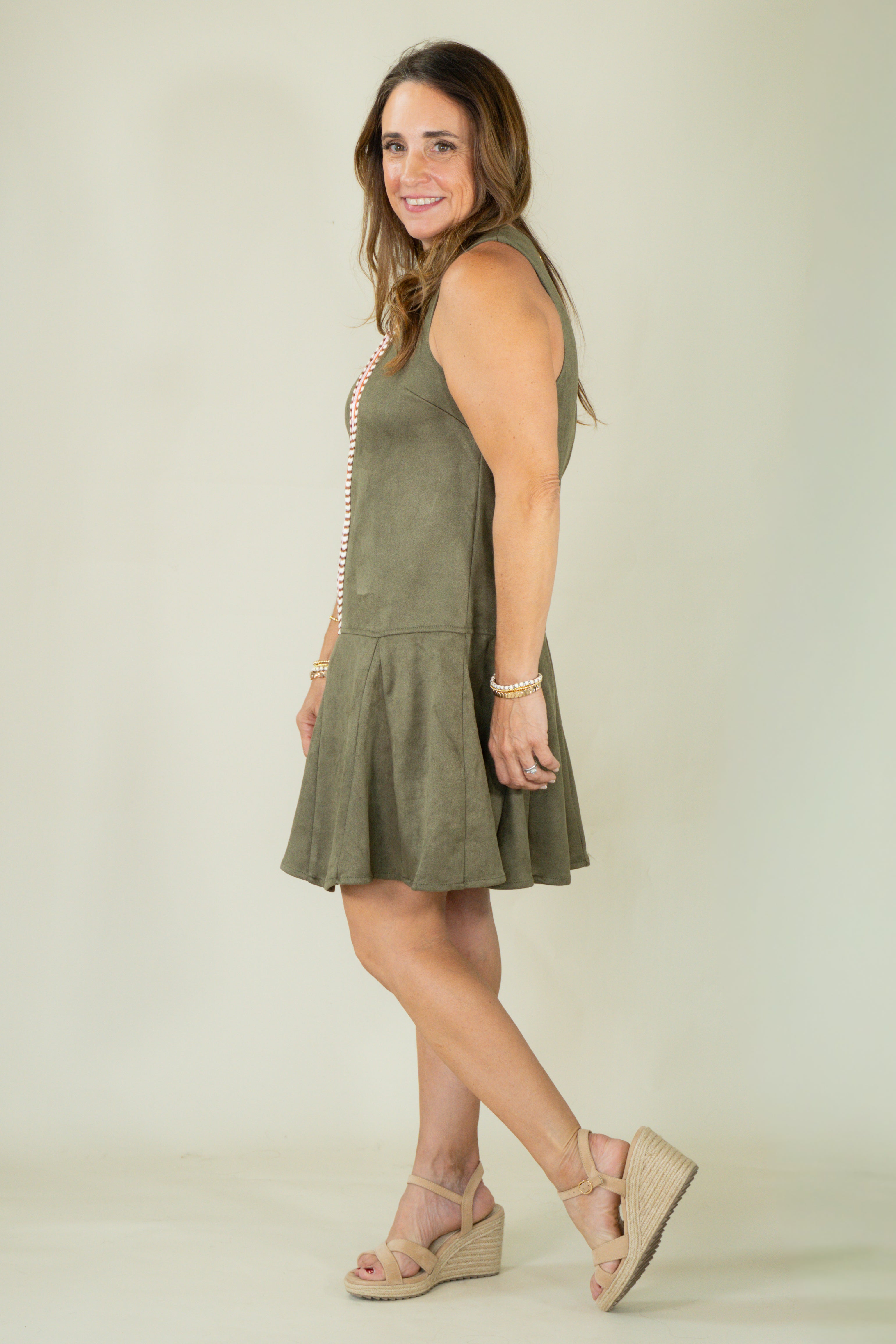 Woman wearing olive suede racing stripe dress with tan wedges
