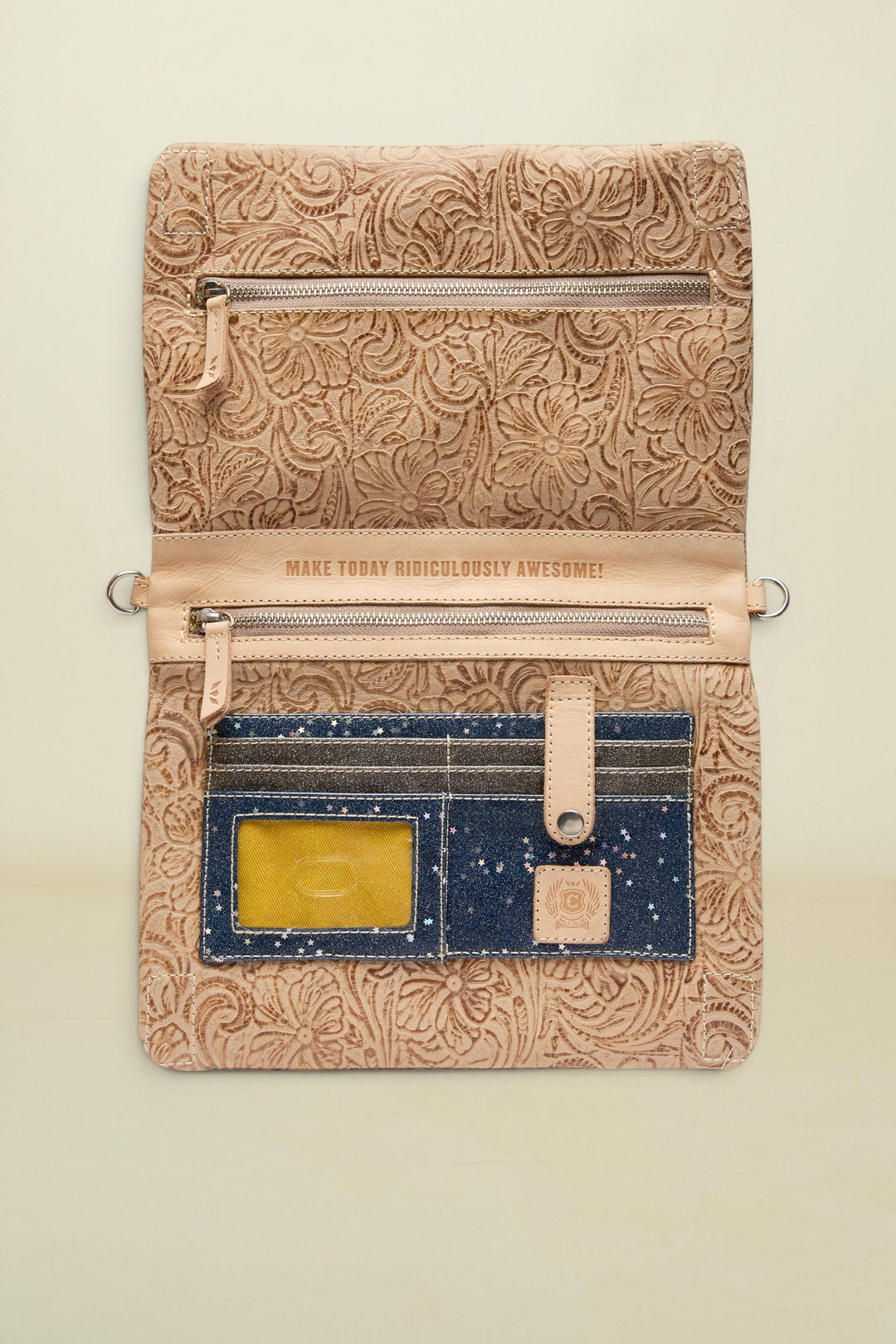 Patterned leather pouch with a motivational quote on a white background