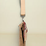 Beige crossbody bag with a strap on a white background