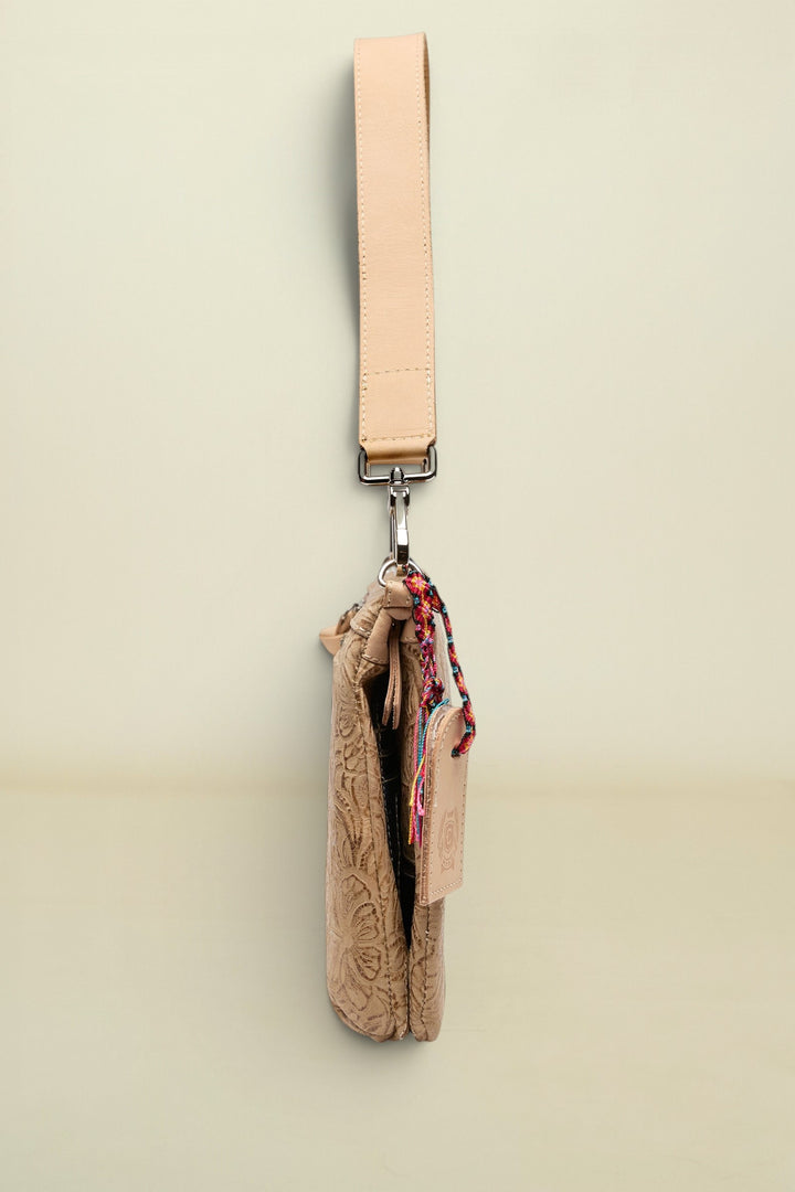 Beige crossbody bag with a strap on a white background