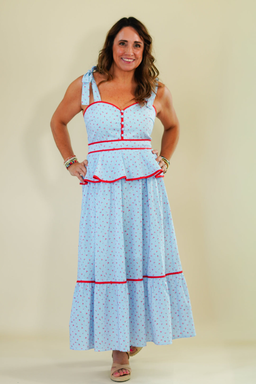 Woman wearing a light blue dress with red accents on a beige background