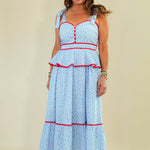 Woman wearing a light blue dress with red accents on a beige background