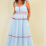 Woman wearing a light blue dress with red accents on a beige background