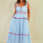 Woman wearing a light blue dress with red accents on a beige background