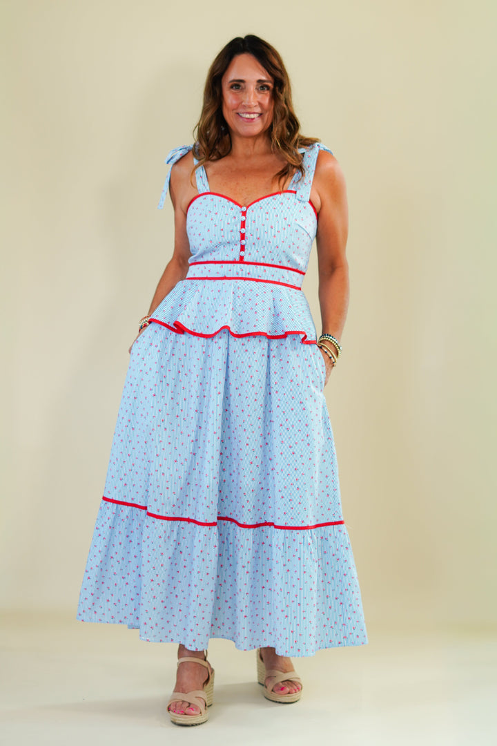 Woman wearing a light blue dress with red accents on a beige background