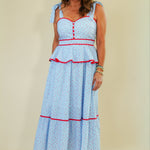 Woman wearing a light blue dress with red accents on a beige background