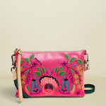 Pink crossbody bag with floral designs on a white background