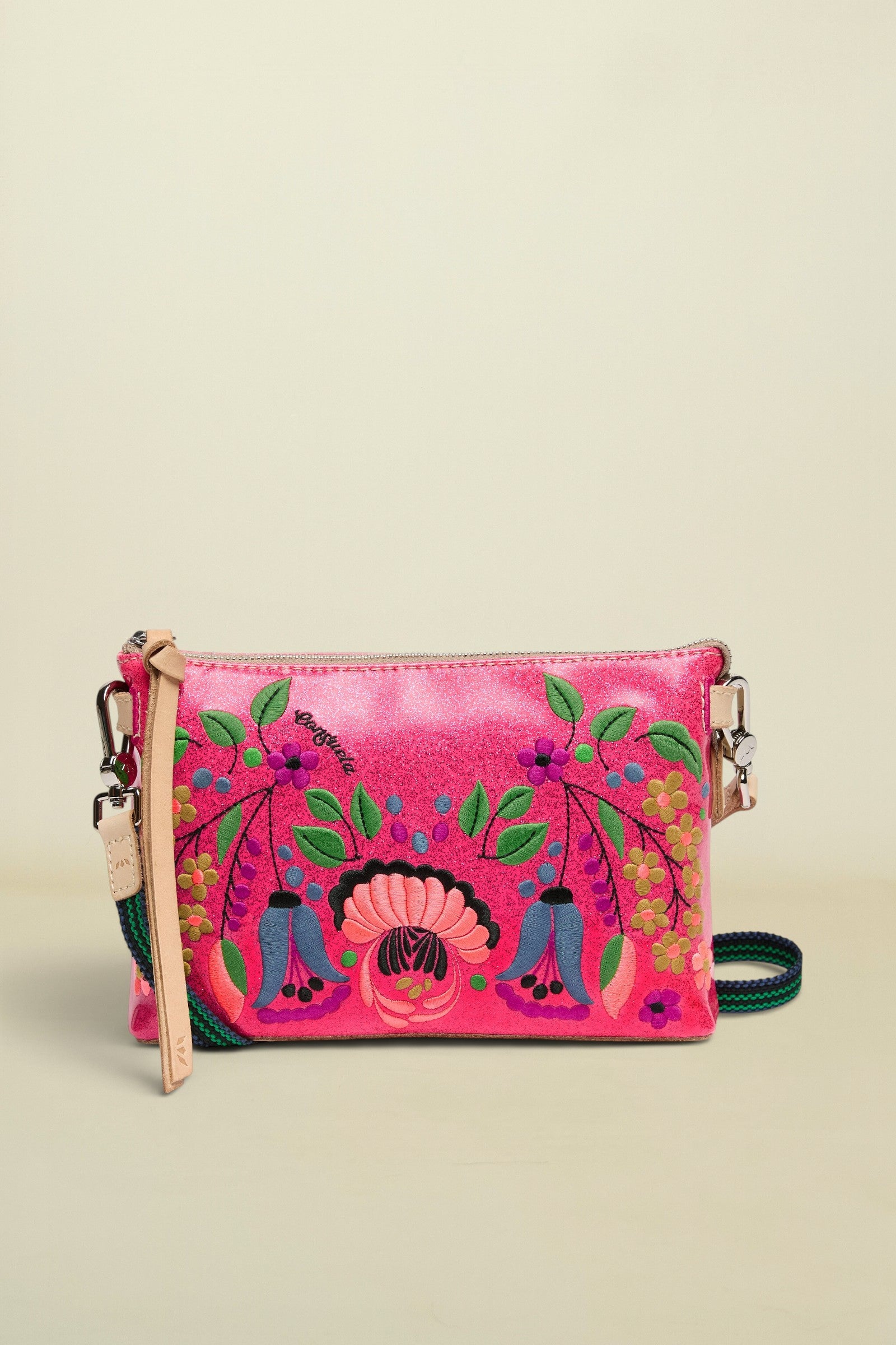 Pink crossbody bag with floral designs on a white background