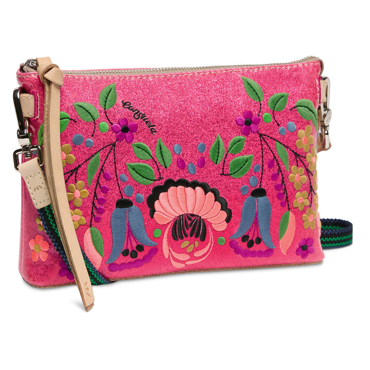 Pink clutch with colorful floral and figure design on a white background